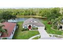 Beautiful single-story home situated on a lush green lot with scenic water views and a vibrant landscape at 5331 Villagebrook Dr, Wesley Chapel, FL 33544