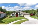 Attractive single-story home with green lawn and mature landscaping, near water and adjacent home at 5331 Villagebrook Dr, Wesley Chapel, FL 33544