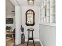 Welcoming foyer with decorative mirror, a bookshelf, and hardwood floors at 610 N Woodlynne Ave, Tampa, FL 33609