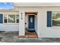 Close-up of the home's entry featuring a blue door with glass panel and tiled front porch at 610 N Woodlynne Ave, Tampa, FL 33609