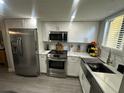 Modern kitchen featuring stainless steel appliances, white cabinetry, and a contemporary farmhouse sink at 9007 Pebble Creek Dr # 9007, Tampa, FL 33647