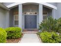 Elegant front entrance with double doors, flanked by lush greenery and classic architectural details at 1003 Berkshire Ln, Tarpon Springs, FL 34688