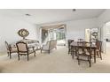 Bright living room featuring neutral decor, a dining area, and seamless access to the screened lanai at 1003 Berkshire Ln, Tarpon Springs, FL 34688