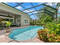 Screened-in pool area with brick pavers, mature landscaping, and a comfortable outdoor seating area at 14817 Tudor Chase Dr, Tampa, FL 33626