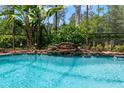 Tranquil pool with a stone waterfall feature and lush landscaping at 14817 Tudor Chase Dr, Tampa, FL 33626