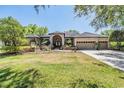 Attractive single-story home boasts a three-car garage and long driveway leading to an arched double door entrance at 15810 Stanton Ln, Tampa, FL 33647