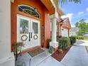 Inviting front entrance features decorative glass doors, a welcome sign, and manicured landscaping at 1626 Brooksbend Dr, Wesley Chapel, FL 33543