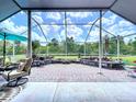 Enclosed patio with brick flooring, outdoor furniture, and scenic views of the backyard at 1626 Brooksbend Dr, Wesley Chapel, FL 33543