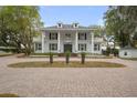 Beautiful stately home featuring symmetrical columns, upper balconies,dormers, and a circular brick driveway, creating a grand curb appeal at 17062 Comunidad De Avila, Lutz, FL 33548
