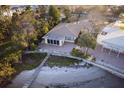 Aerial view of waterfront property with a dock, lush landscaping, and a screened-in porch at 175 Bath Club N Blvd, North Redington Beach, FL 33708
