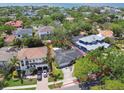 Aerial view of the property, surrounded by lush greenery and neighboring houses with a glimpse of the ocean at 2607 S Bryant Cir, Tampa, FL 33629