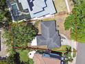 Aerial shot of the property featuring a house with a dark roof and lush surrounding trees, as defined by a red perimeter at 2607 S Bryant Cir, Tampa, FL 33629