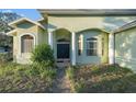 Inviting home entrance with a pathway, pillars, decorative windows and landscaping at 3545 E Lake Dr, Land O Lakes, FL 34639