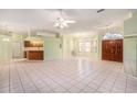 Open-concept living room featuring tile floors, natural light, and a seamless flow to the kitchen at 3545 E Lake Dr, Land O Lakes, FL 34639