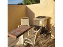 Enclosed outdoor patio featuring a table and chairs next to the home's air conditioning unit at 38243 Ironwood Pl, Zephyrhills, FL 33542