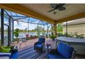 Screened lanai with comfortable seating overlooking a serene lake view and includes a hot tub at 4811 Sandy Glen Way, Wimauma, FL 33598