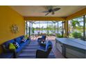 Covered lanai with lake views, comfortable seating, and a relaxing hot tub at 4811 Sandy Glen Way, Wimauma, FL 33598