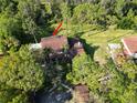 A beautiful aerial view of a home surrounded by tall trees and a spacious lawn at 5454 Saddlebrook Way # 2, Wesley Chapel, FL 33543