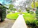 Scenic view of the well-manicured front yard showcasing lush landscaping and a welcoming pathway at 5454 Saddlebrook Way # 2, Wesley Chapel, FL 33543