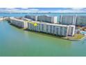 Aerial view of condo building and surrounding waterfront showing location of unit indicated by the yellow arrow at 6075 Shore S Blvd # 509, Gulfport, FL 33707
