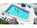 Aerial view of the pristine community pool surrounded by lounge chairs and tiki umbrellas at 6075 Shore S Blvd # 509, Gulfport, FL 33707