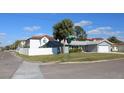 Corner lot home with white fence, lush lawn, and a charming exterior view on a sunny day at 6225 Imperial Ky, Tampa, FL 33615