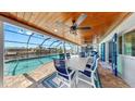 Covered lanai with a dining table overlooking the pool and waterfront views at 6511 Senegal Palm Way, Apollo Beach, FL 33572