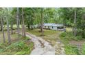 Wide aerial view of the home with a long driveway, large lot and mature trees surrounding the property at 7249 Berry Rd, Zephyrhills, FL 33540