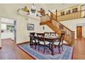 Formal dining room with wood floors, ceiling fan, adjacent staircase, and views of the upstairs landing at 7591 Harbor View Way, Seminole, FL 33776