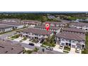 Exterior view of tan townhomes with attached garages and manicured lawns at 8299 Crescent Oaks Dr, New Port Richey, FL 34655