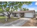 Charming single-story home featuring a well-maintained lawn, mature trees, and an attached garage with a boat parked nearby at 9414 Northcliffe Blvd, Spring Hill, FL 34606