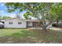Inviting single-Gathering home with a well-manicured front lawn, mature shade trees, and a cozy, welcoming entrance at 9414 Northcliffe Blvd, Spring Hill, FL 34606