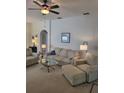 Cozy living room with comfortable striped furniture, a ceiling fan, and ample natural light creating a warm ambiance at 9608 Rolling Cir, San Antonio, FL 33576