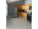 Kitchen featuring stainless steel appliances, light wood cabinets, and tile flooring at 10106 Wheatley Hills Ct, Tampa, FL 33615