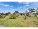 Well-maintained single-story home with a manicured lawn, lush bushes, and a charming white picket fence at 105 6Th Nw St, Ruskin, FL 33570