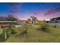 Inviting single-story home with well-kept lawn and blooming bushes under a colorful dusk sky at 105 6Th Nw St, Ruskin, FL 33570