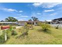 Inviting single-story home with well-kept lawn and blooming bushes under a bright, cloudy sky at 105 6Th Nw St, Ruskin, FL 33570