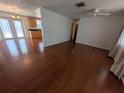 Hardwood floors extend from the open living room to the kitchen with bright natural light at 10968 105Th Ave, Largo, FL 33778