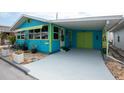 Blue and green house with white carport and a cheerful exterior design, enhancing the home's curb appeal at 11 Lafayette St, Bradenton, FL 34208