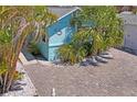 Cozy blue home with tropical foliage and brick paver driveway at 13123 4Th E St, Madeira Beach, FL 33708