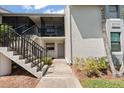 Exterior of condo featuring stairs, a small door, and green grass at 2017 Skimmer W Ct # 416, Clearwater, FL 33762