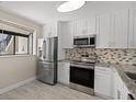 Modern kitchen with stainless steel appliances and white cabinets at 2017 Skimmer W Ct # 416, Clearwater, FL 33762