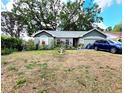 Charming single-story home featuring a well-kept lawn, two-car garage, and mature shade trees at 2114 W Hanna Ave, Tampa, FL 33604