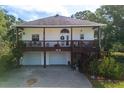 Charming two-story home featuring a wraparound porch, front-facing garages, and a beautifully landscaped yard at 301 1/2 Shore E Dr, Oldsmar, FL 34677