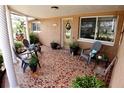 Inviting front porch featuring a tile floor, seating area, and a decorated front door at 3302 Eisenhower Dr, Holiday, FL 34691