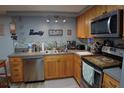 Well-lit kitchen with stainless steel appliances, wooden cabinets, and modern countertops at 3302 Eisenhower Dr, Holiday, FL 34691