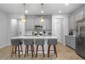 Bright kitchen with gray cabinets, quartz countertops, pendant lighting, and stainless appliances at 4236 Cloud Hopper Way, Lutz, FL 33559