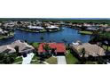 Stunning aerial view of waterfront homes with beautiful red tile roofs and lush green landscaping along canals at 4804 Longwater Way, Tampa, FL 33615