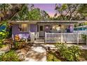 Charming purple home with manicured landscaping and a cozy front porch at 522 James St, Dunedin, FL 34698
