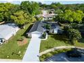 Aerial view of the house showing driveway, and backyard with a tree-lined neighborhood at 7504 Lily Pad Ct, Hudson, FL 34667